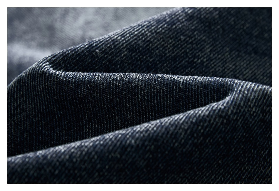 Close-up of dark indigo denim fabric folded to show its diagonal weave.
