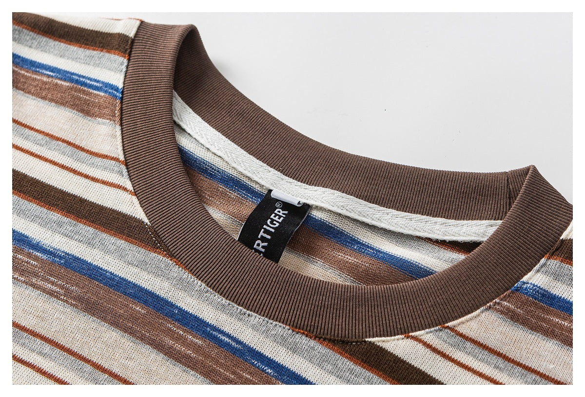 Close-up of a brown ribbed crew neckline on a cream shirt with brown, gray, and blue stripes; a sewn-in label is visible.