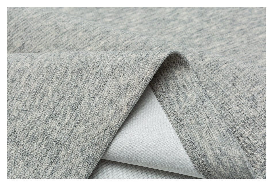 Close-up of a folded edge on gray marl knit fabric, showing the stitched seam finish.