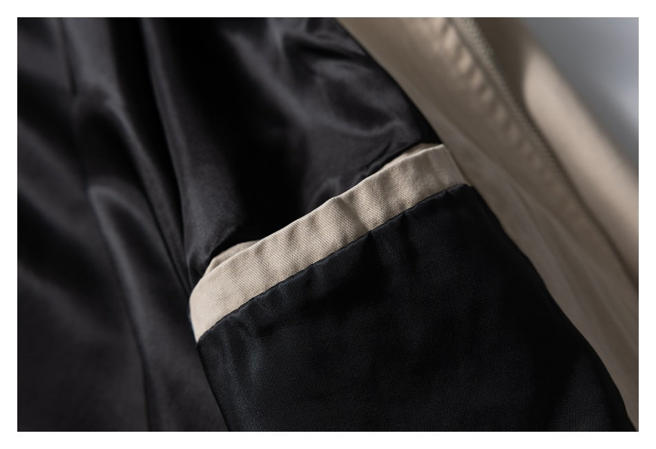 Close-up of the beige jacket's black lining and interior pocket.