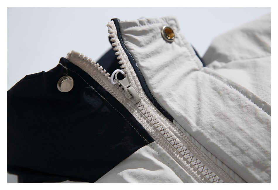 Close-up of the light jacket's zipper, snap fasteners and dark interior lining.
