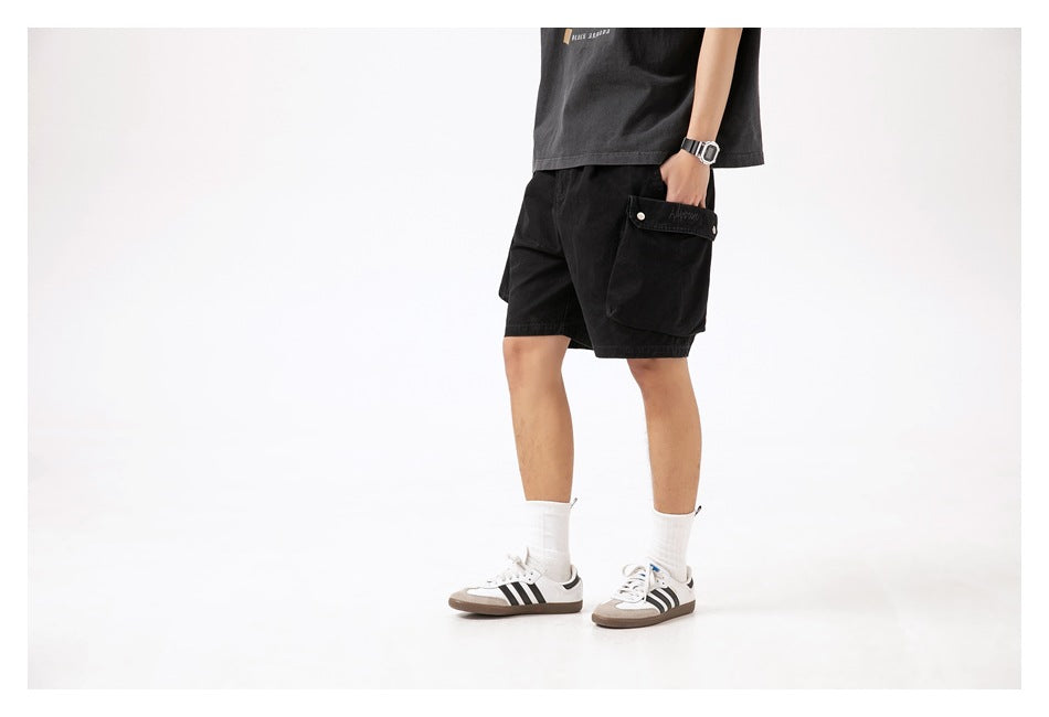 Side view of a model wearing black cargo shorts with a large flap pocket.