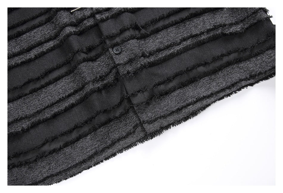 Close-up of the black shirt's striped front fabric, frayed trim and buttoned placket.