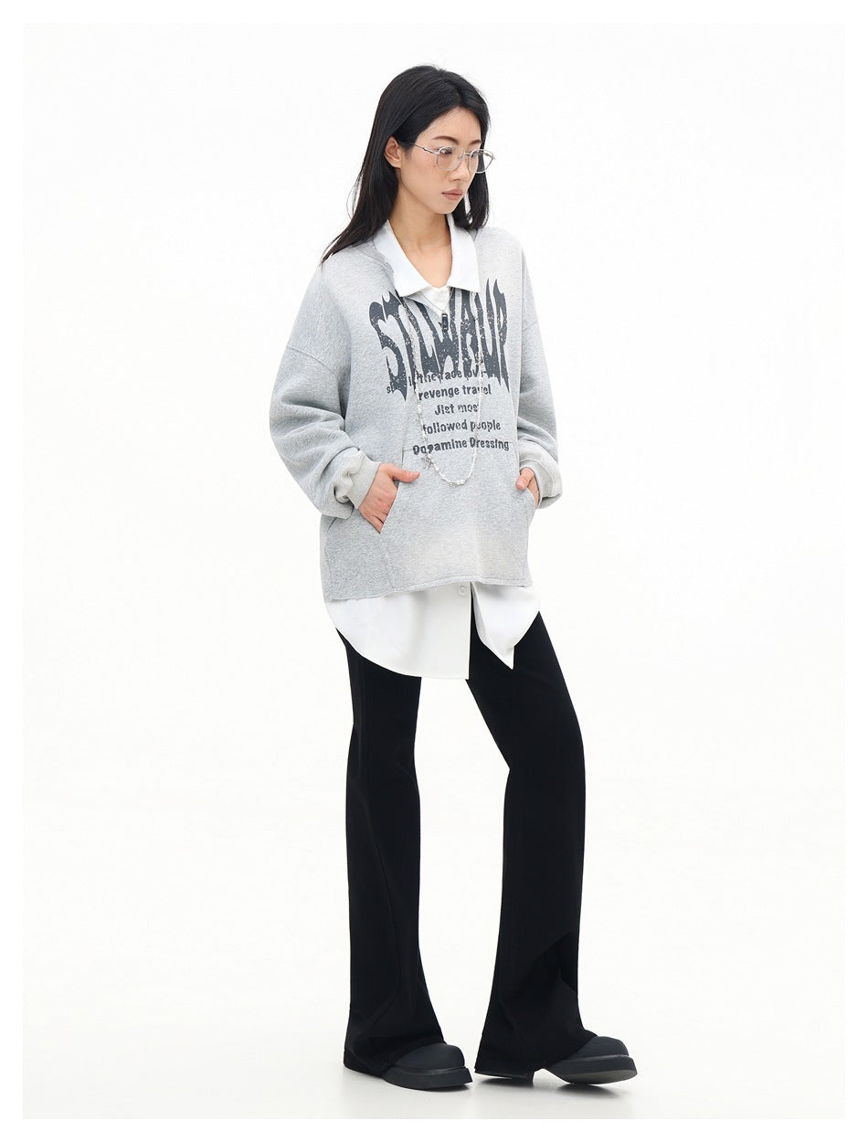 Full-length model in a light gray graphic sweatshirt layered over a white shirt and black flared pants.