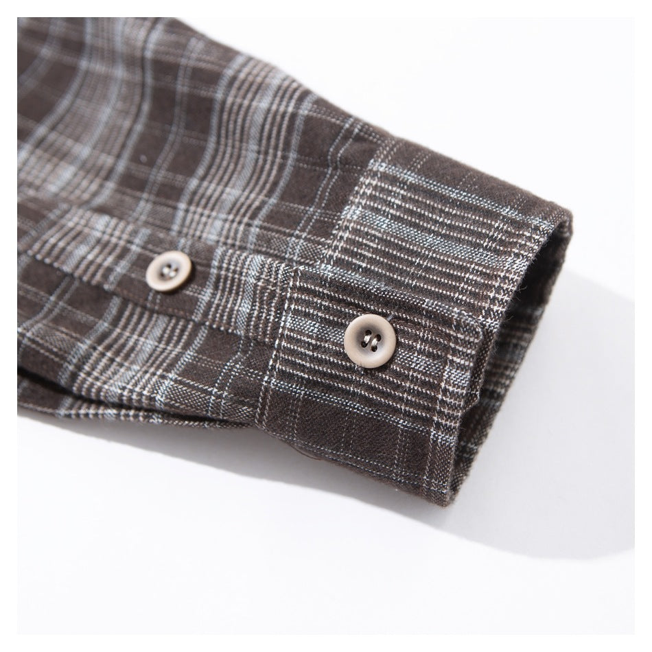 Close-up of a dark brown plaid shirt cuff with two buttons.