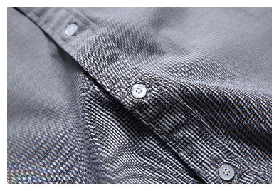 Close-up of the gray shirt's button placket and fine textured fabric.