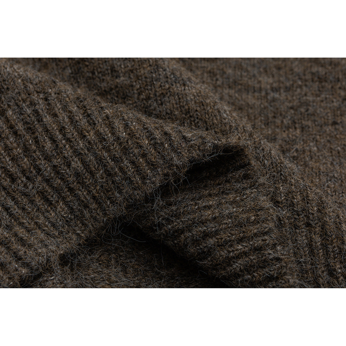 Close-up of dark brown knit fabric with a folded edge and visible fuzzy texture.
