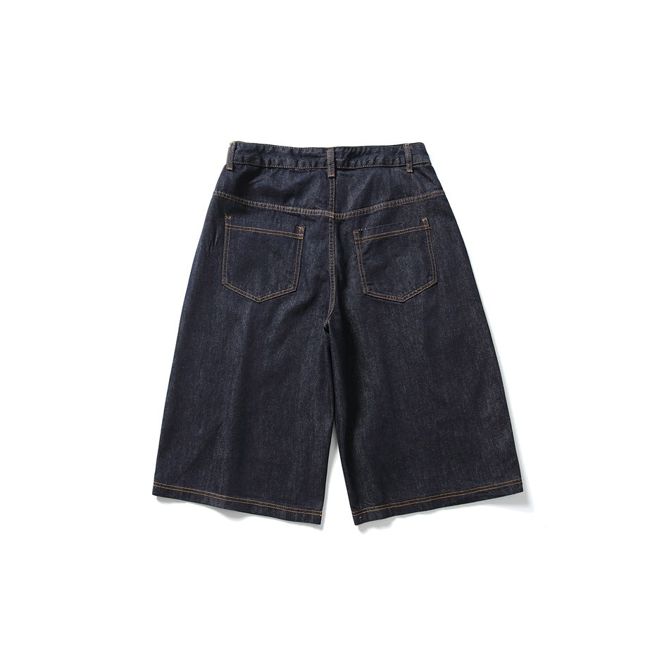 Back view of dark indigo wide-leg denim shorts with two patch pockets and contrast stitching, laid flat.