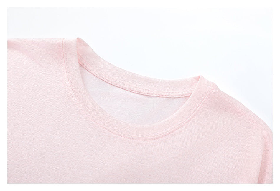 Close-up of a pale pink crew-neck shirt showing the neckline and shoulder seams.