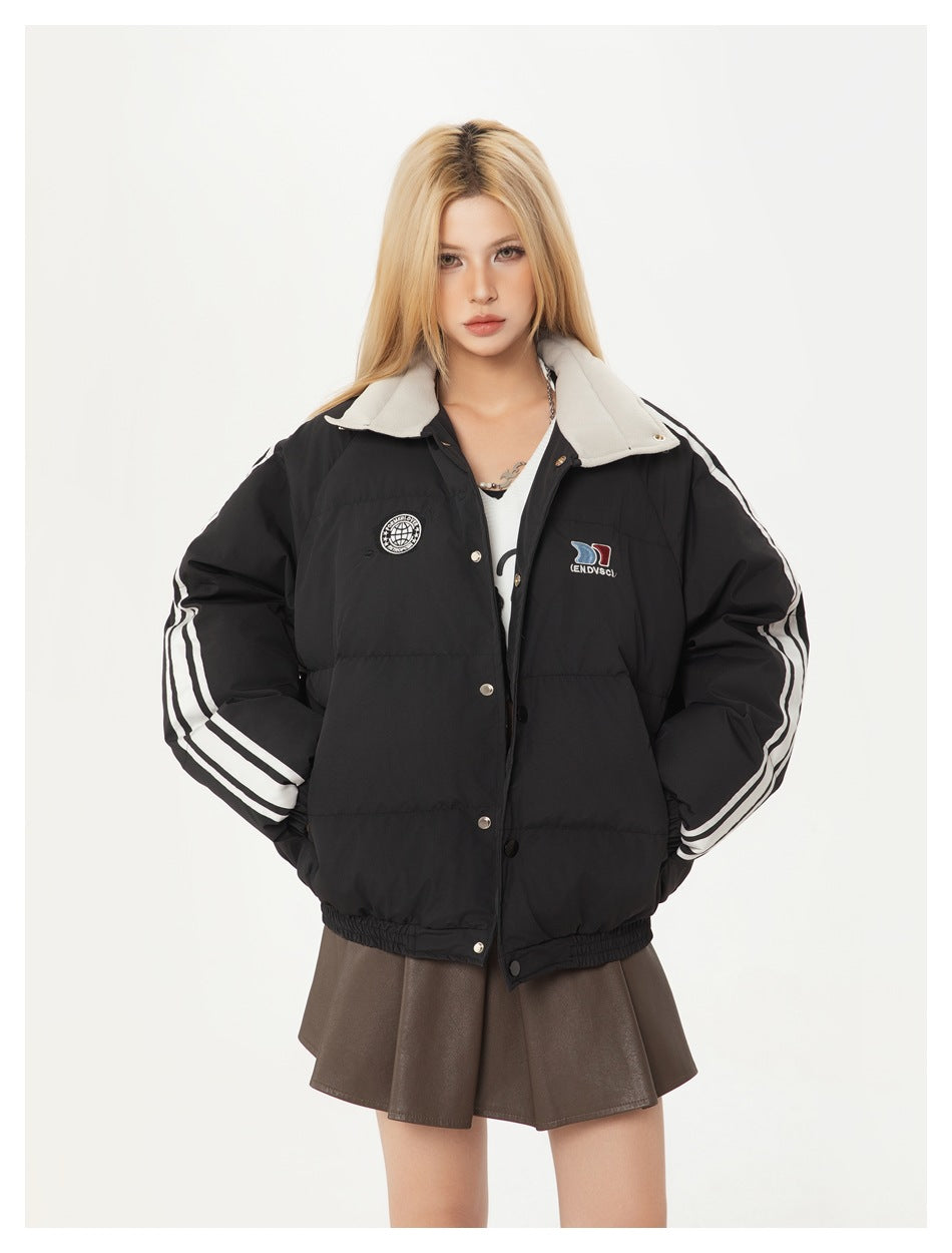 Front view of a model wearing a black quilted jacket with a light collar, white sleeve stripes and chest patches.