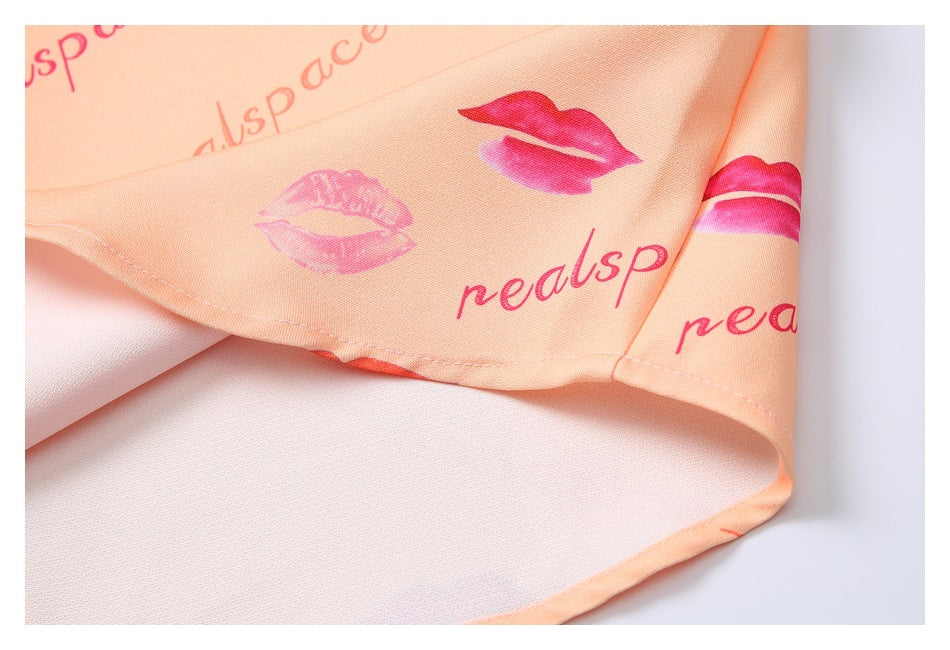 Close-up of a stitched edge and underside of peach fabric with pink lips and lettering.