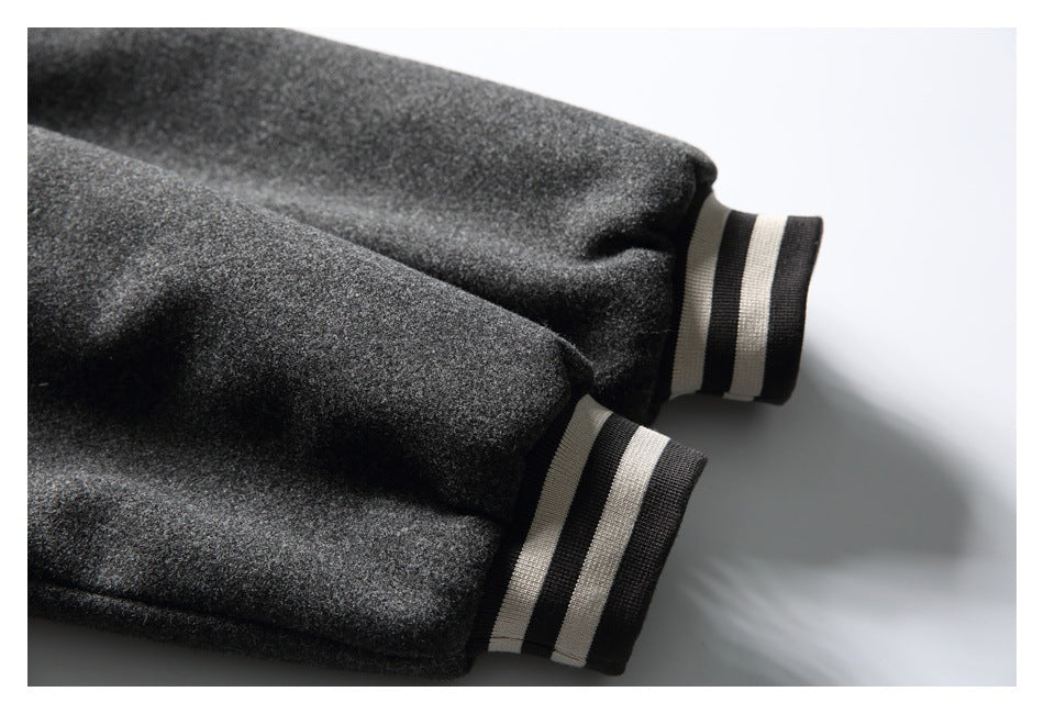 Close-up of the charcoal jacket sleeves ending in black-and-cream striped ribbed cuffs.