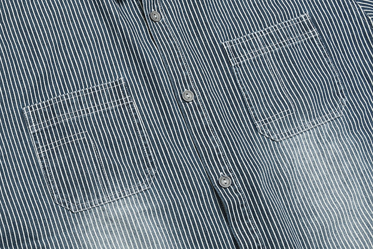 Cropped front view of a dark blue pinstriped shirt with two chest pockets and gray buttons.