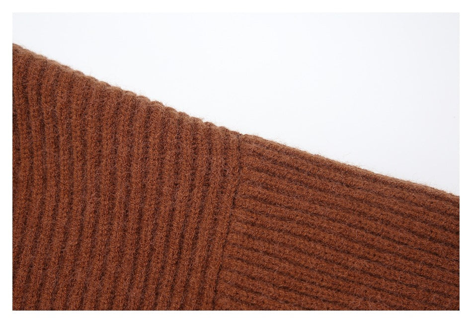 Close-up of the ribbed sleeve seam on a rust-brown cardigan.