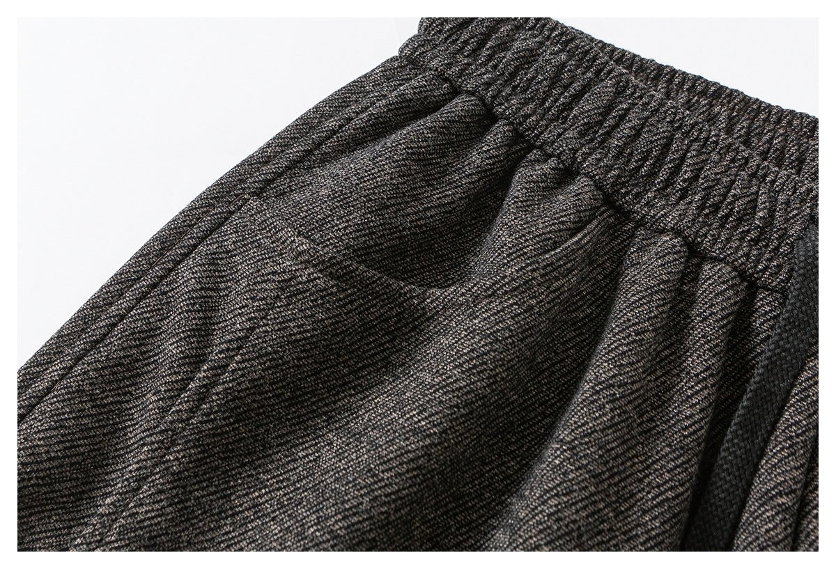Close-up of charcoal gray marled pants showing the gathered elastic waistband and curved front pocket.