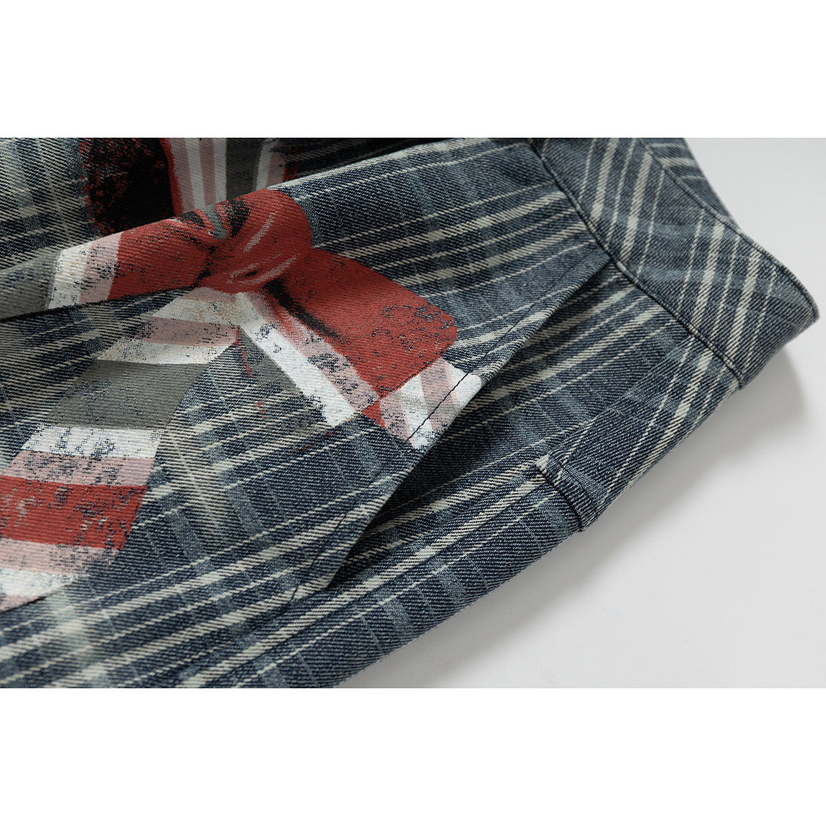 Close-up of blue-gray plaid shorts fabric and a distressed red, white, and gray printed graphic.