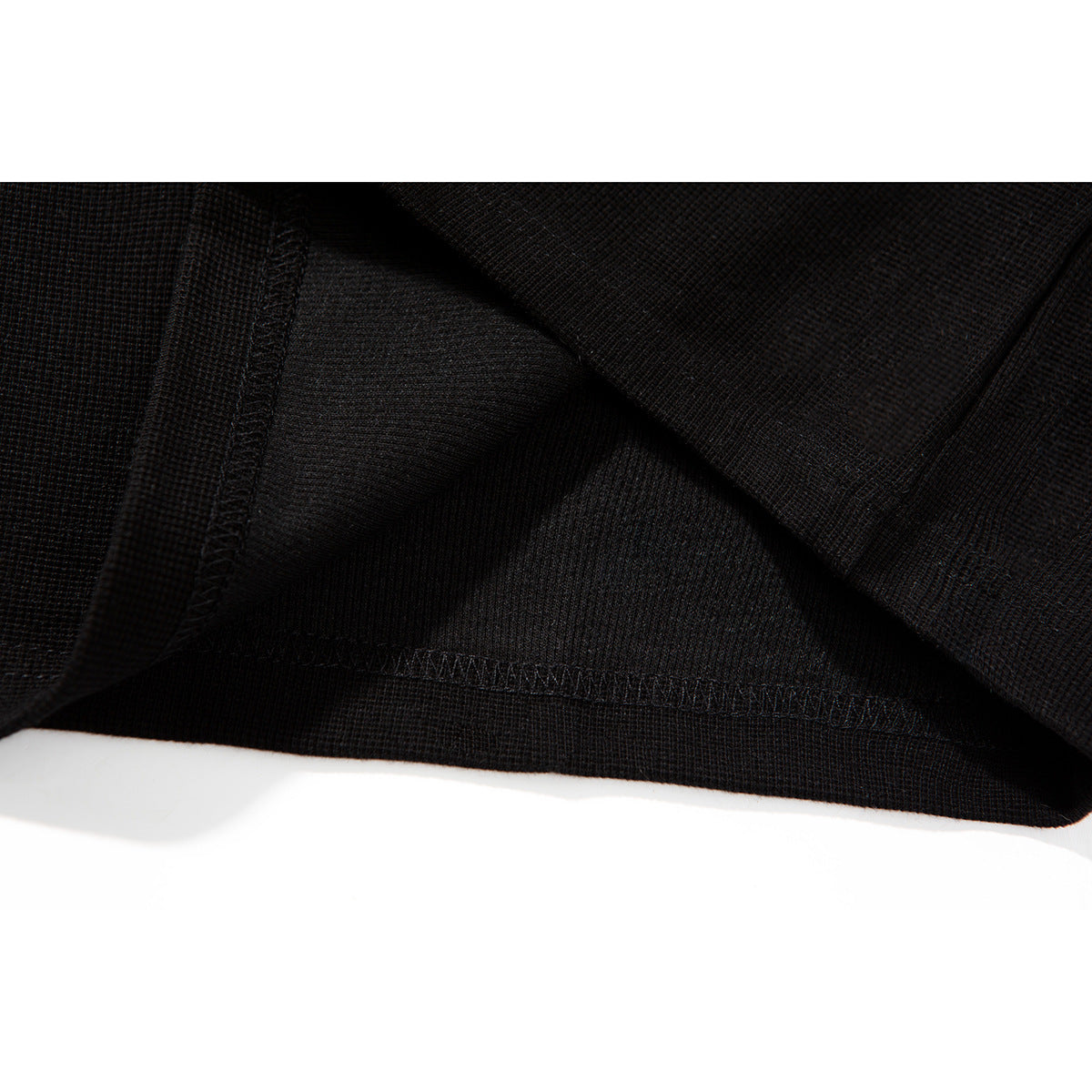 Close-up of the black T-shirt's inside fabric and stitched hem seam.