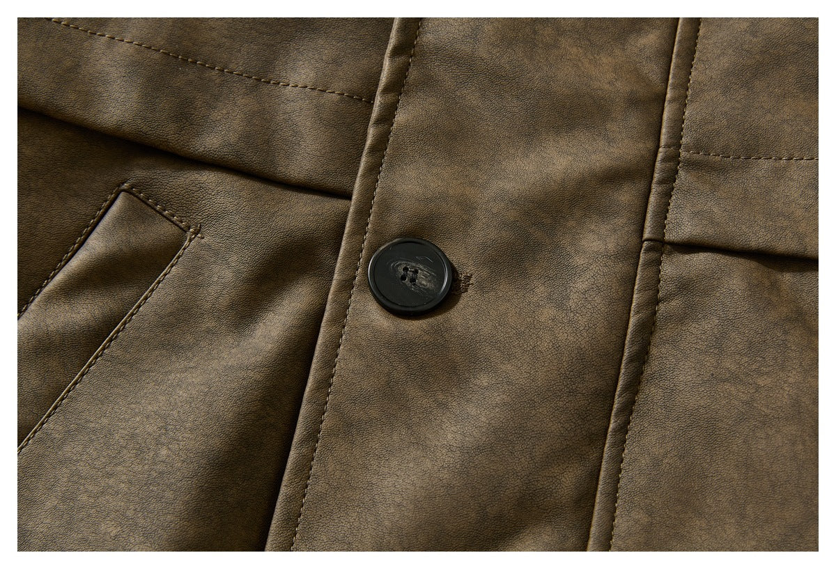 Close-up of the brown jacket’s front panel, black button, and angled welt pocket.