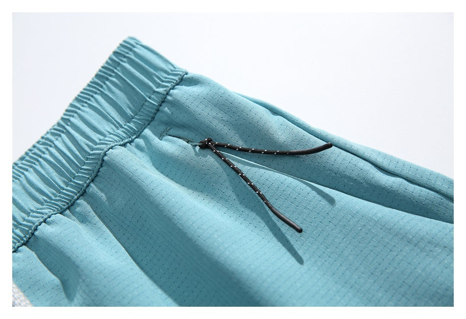 Close-up of light blue shorts showing a black drawstring emerging from the gathered waistband.