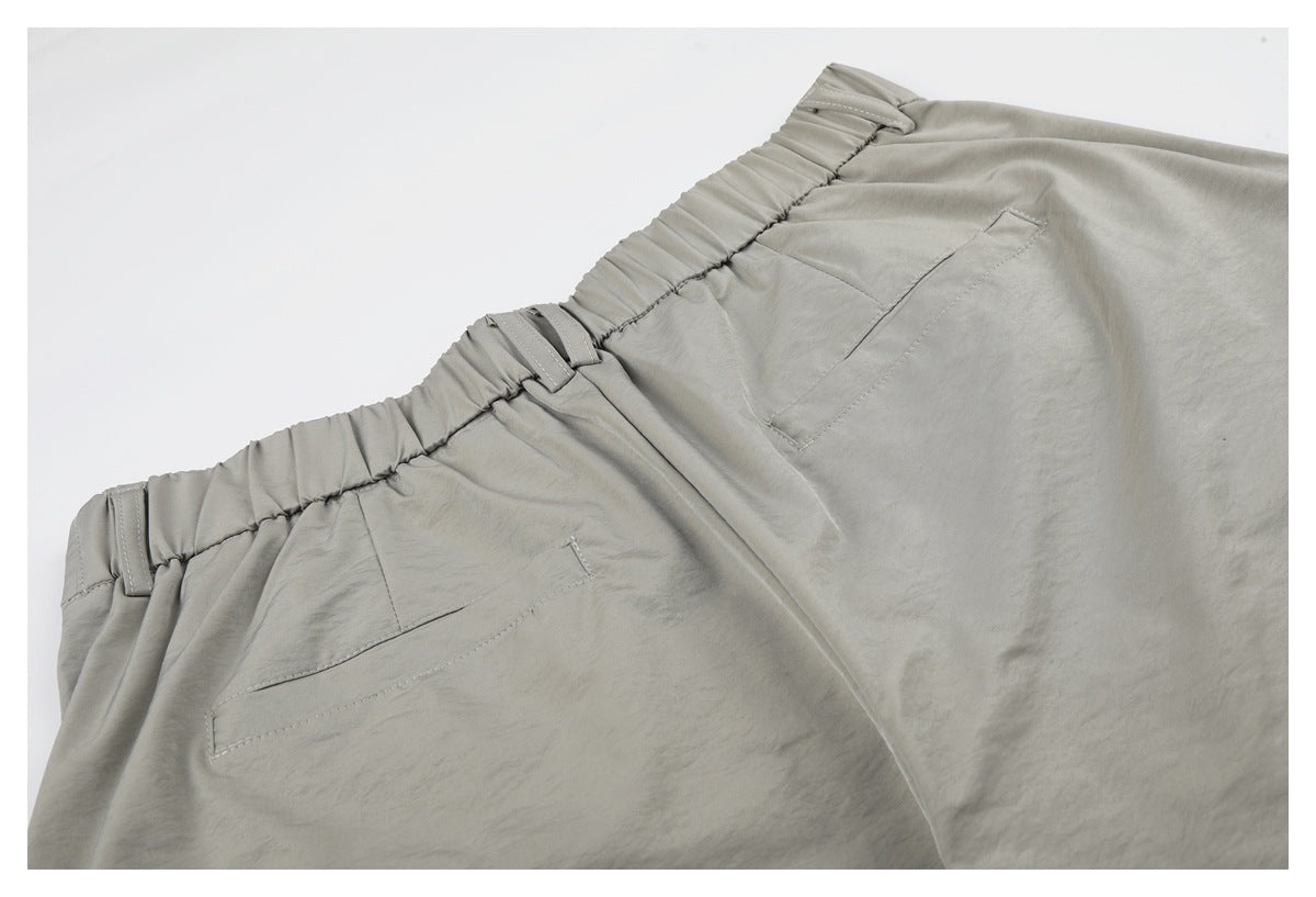 Close-up of the back waistband and pockets on light gray-beige trousers.