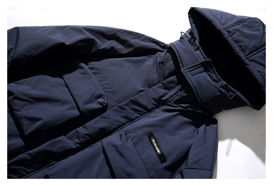 Close-up of a dark navy coat showing its hood, adjustable straps and a small sewn label.