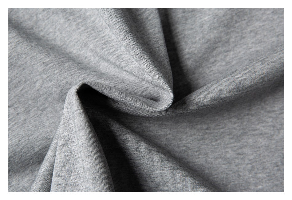 Close-up of heather gray knit fabric draped into soft folds, showing its fine texture.