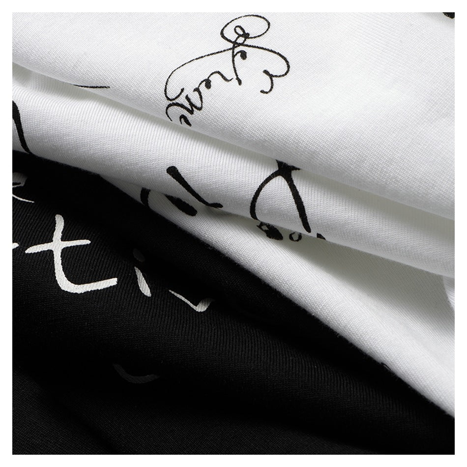 Close-up of folded black and white fabric with contrasting, abstract handwritten-style prints.