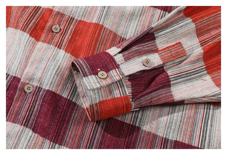 Close-up of the plaid shirt's long sleeve and buttoned cuff laid across the shirt body.