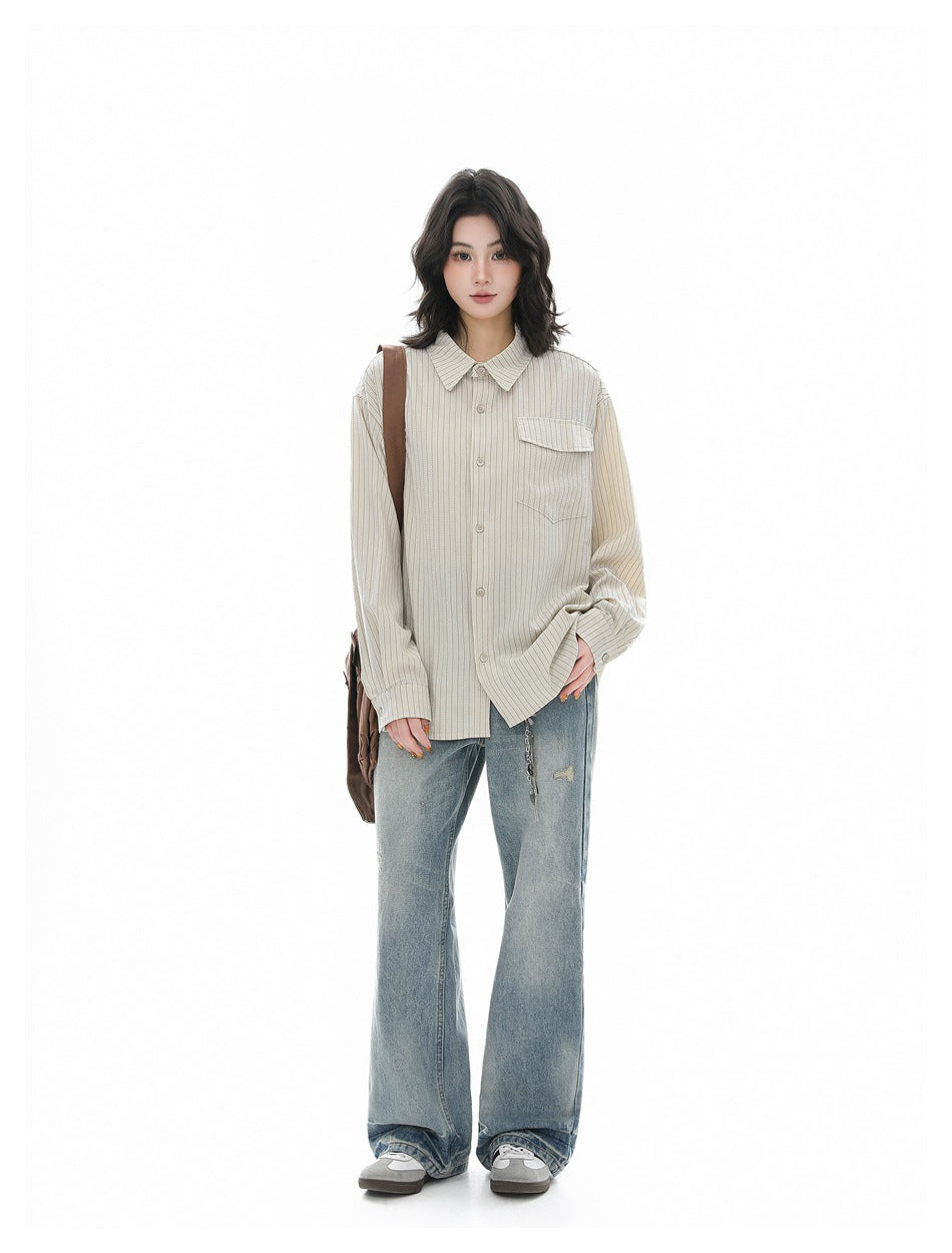 Full-length view of model in apricot pinstripe shirt, light-wash flared jeans and gray sneakers