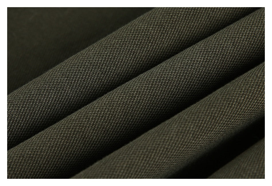 Close-up of dark olive-gray woven fabric folded into diagonal ridges.