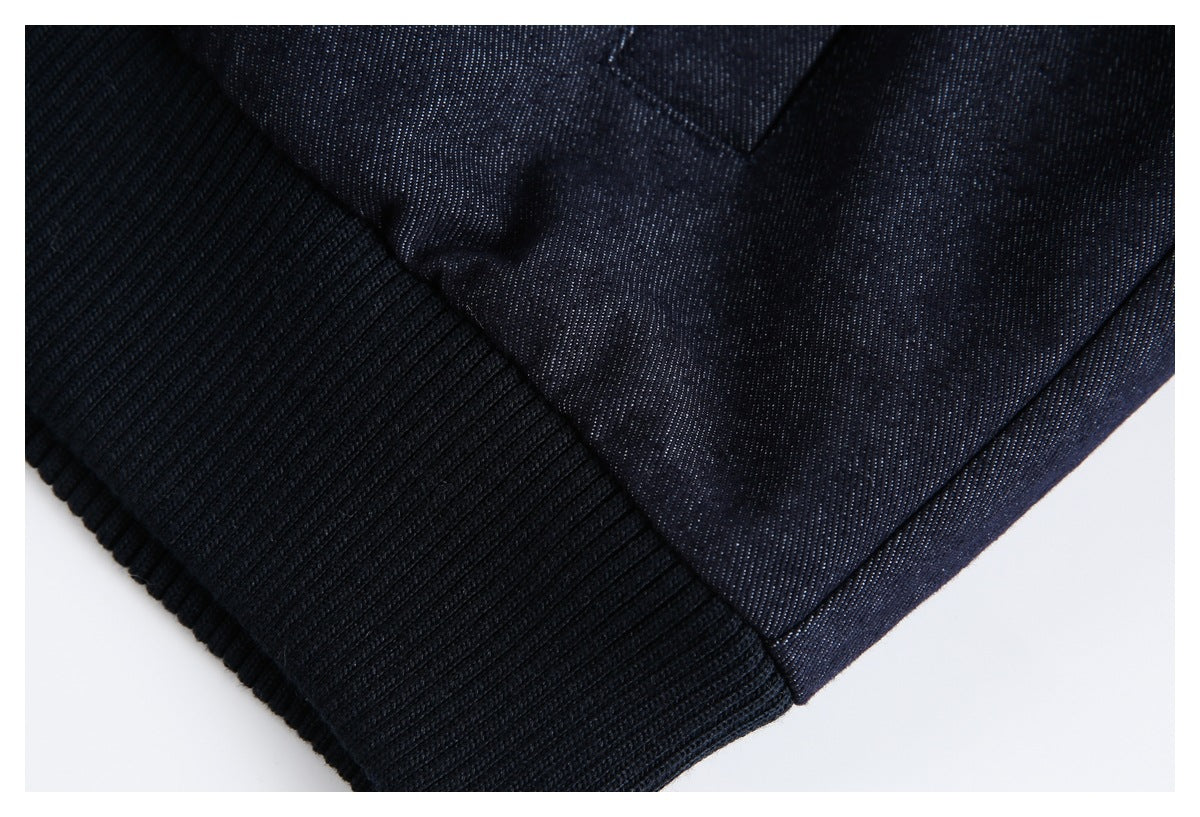 Close-up of a dark navy garment's black ribbed cuff or hem and stitched seam.
