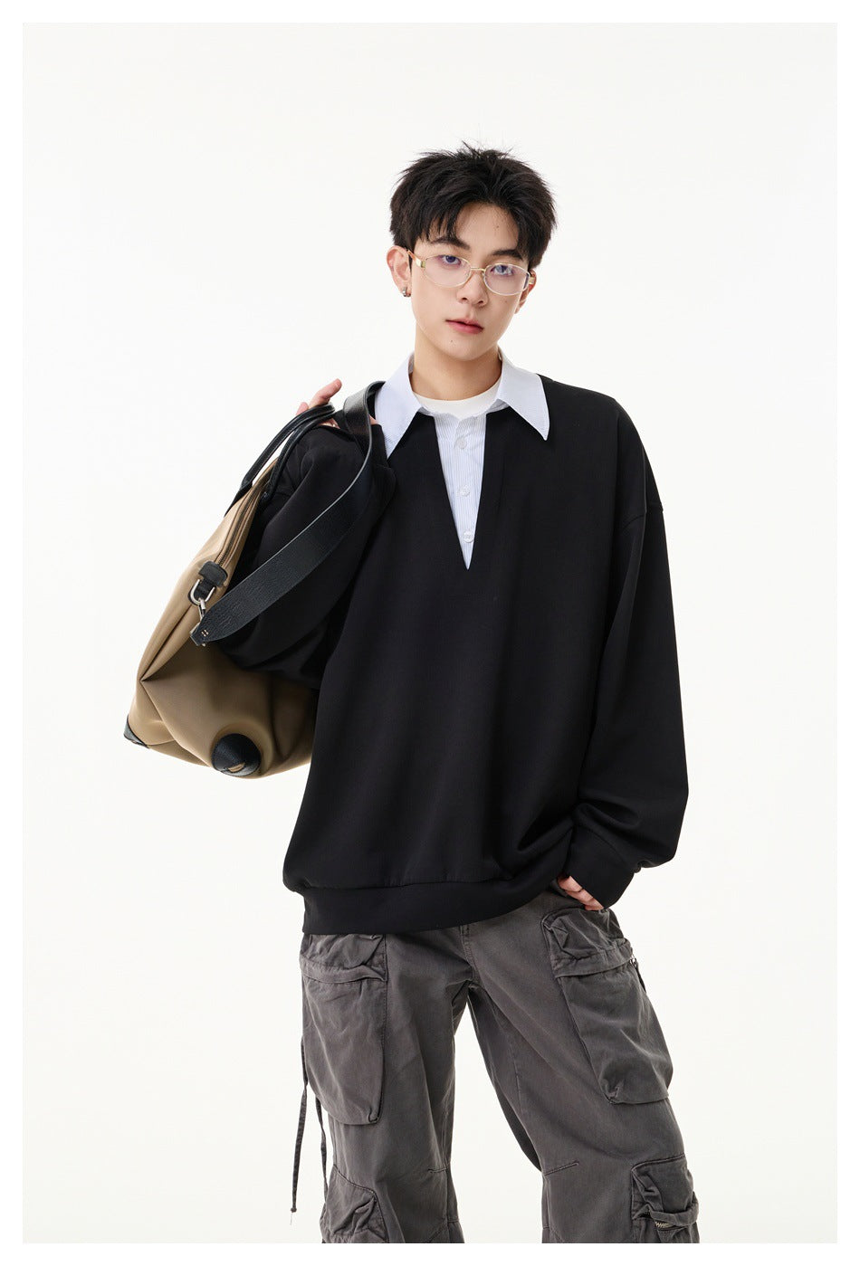 Model wearing an oversized black pullover with a white striped pointed collar and placket.