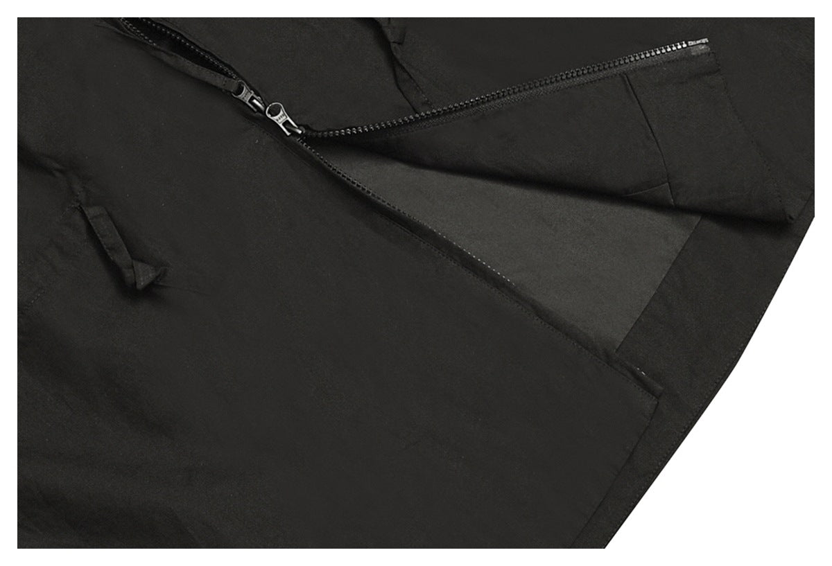 Close-up of a black garment showing a diagonal zipper and a zippered pocket.