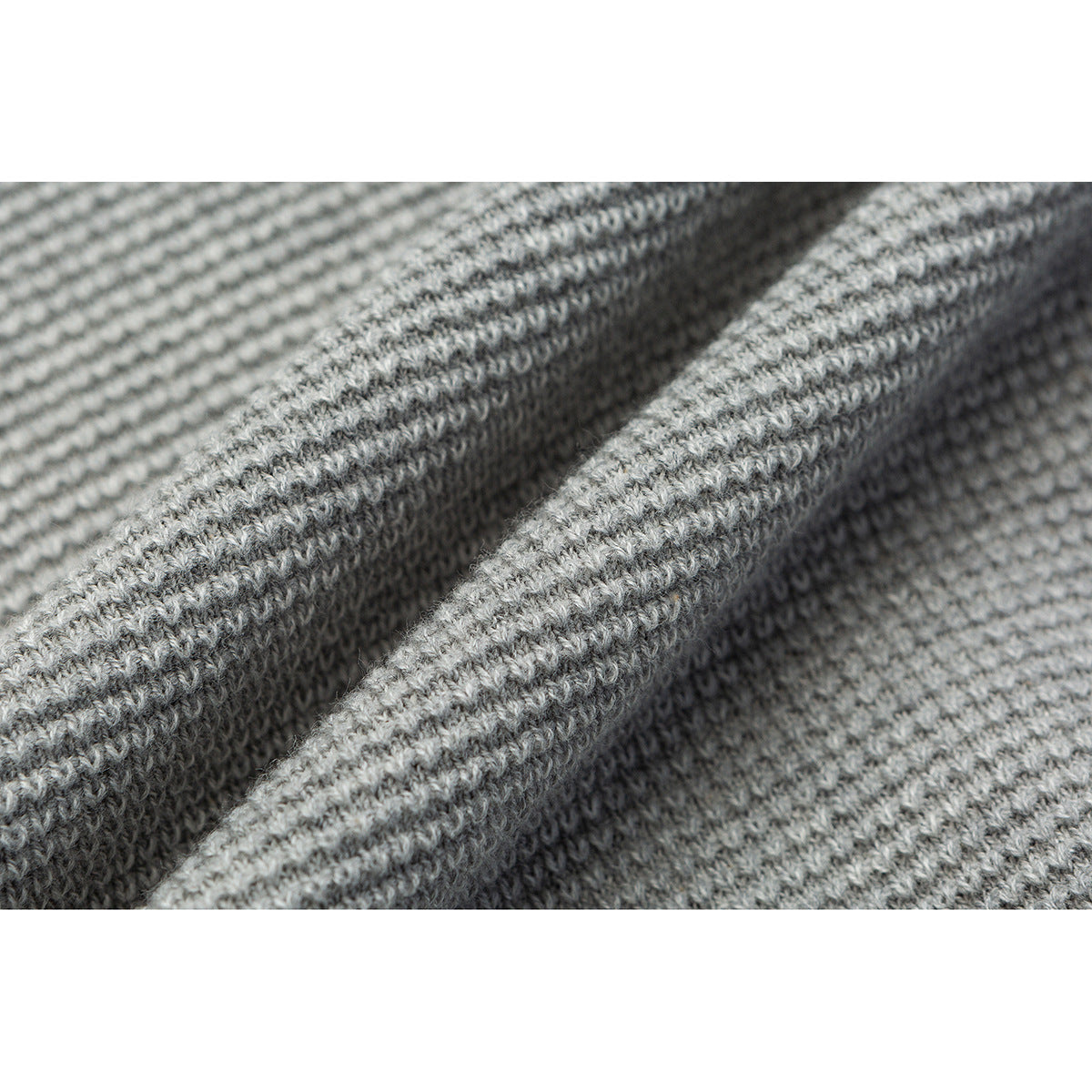 Extreme close-up of the gray knit fabric, highlighting its raised looped texture.