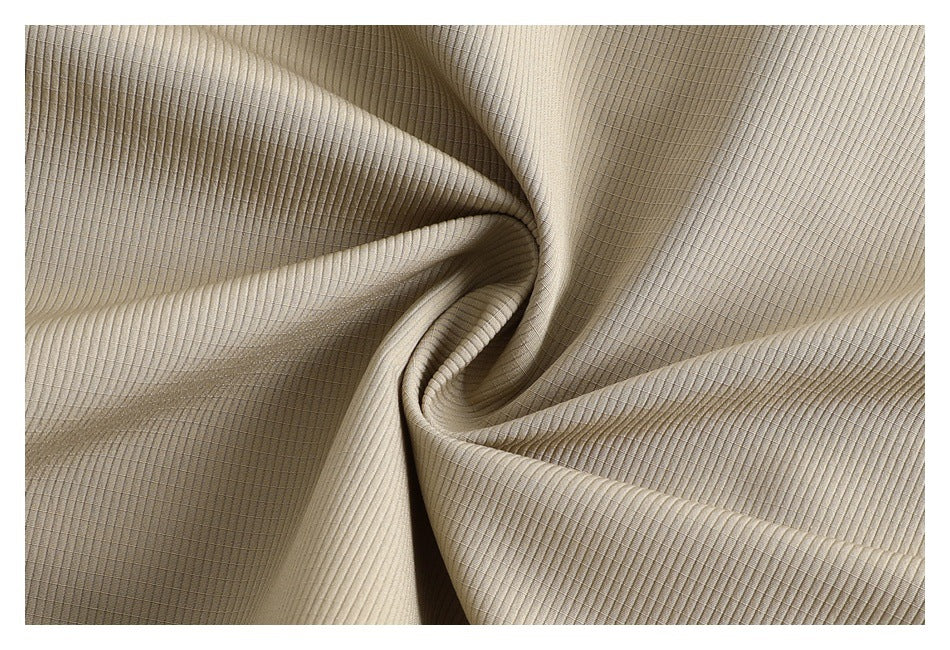Close-up of beige fabric showing a fine ribbed texture and subtle grid-like weave.