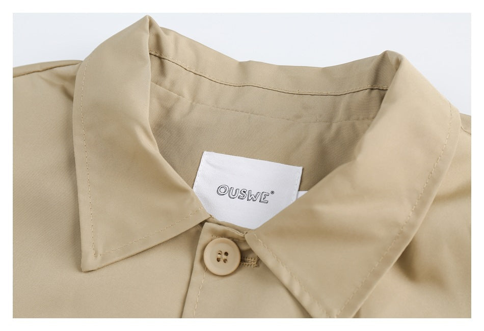 Close-up of the beige coat's pointed collar, top button, and sewn OUSWE label.