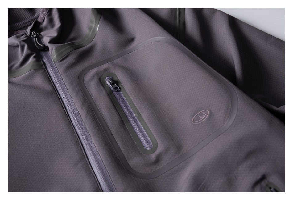 Close-up of the pullover’s chest pocket with a vertical zipper, contrast trim, and small emblem.