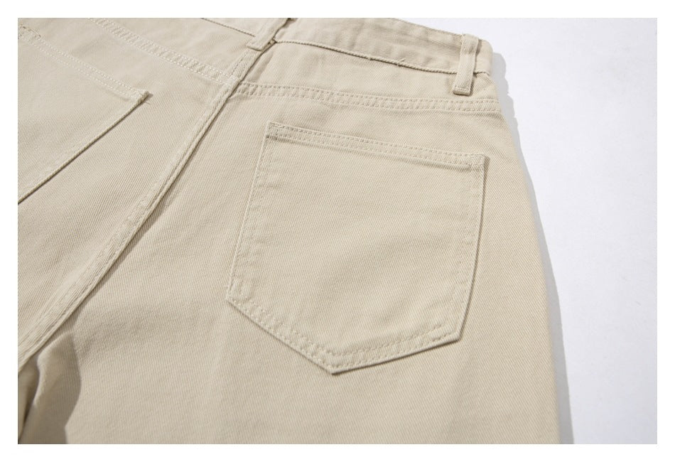 Close-up of the back pocket and waistband of beige pants.
