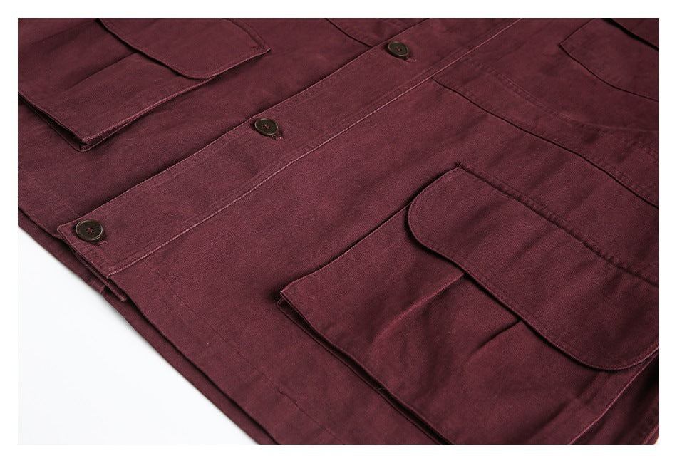 Burgundy jacket laid flat, showing its button placket and multiple flap pockets.