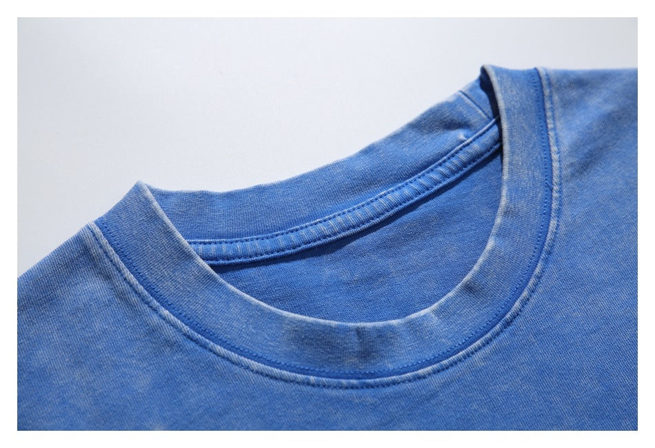 Close-up of a blue T-shirt's ribbed crew neckline and stitching.