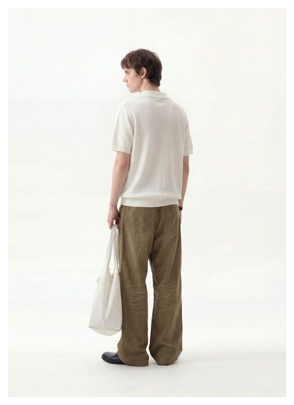 Rear view of a man wearing an ivory short-sleeve polo and olive trousers.