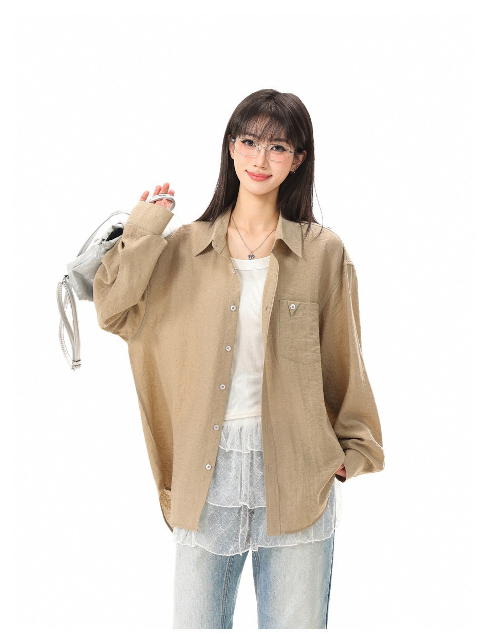 Model wearing a loose tan button-up shirt with a chest pocket, layered over a white top and lace hem.