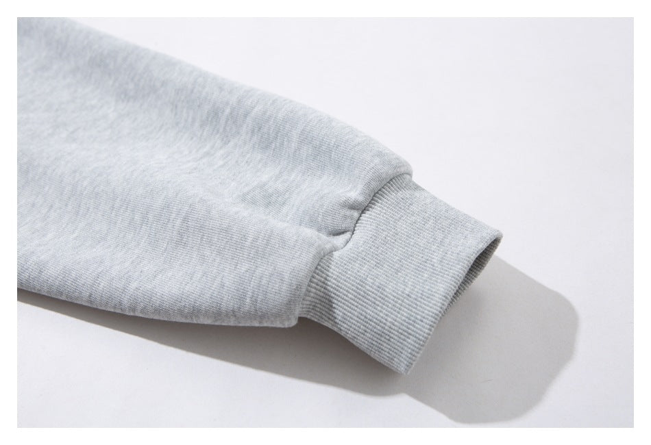 Close-up of a light gray heather sweatshirt sleeve ending in a wide ribbed cuff.