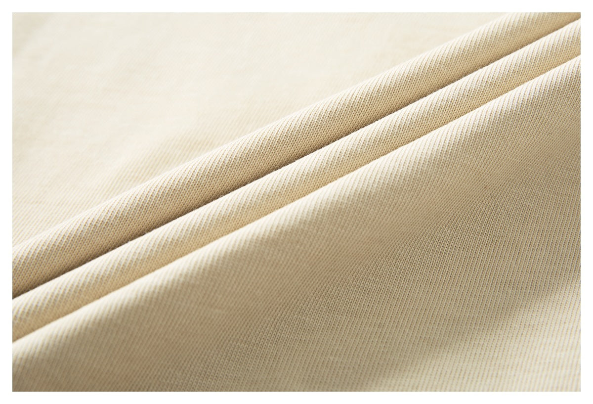 Close-up showing the fine knit texture and soft folds of cream-colored shirt fabric.