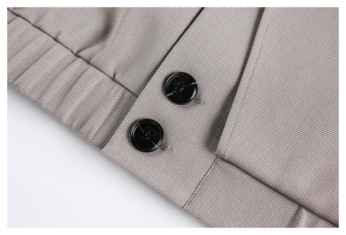 Close-up of a taupe-gray coat cuff with two black buttons and fine diagonal fabric texture.