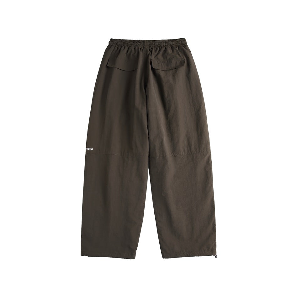 Back view of dark olive-brown cargo pants with an elastic waist and two rear flap pockets.