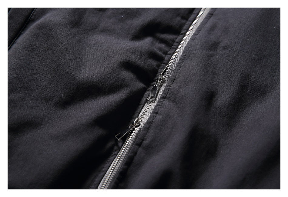Close-up of the black jacket's silver front zipper and dual zipper pulls.