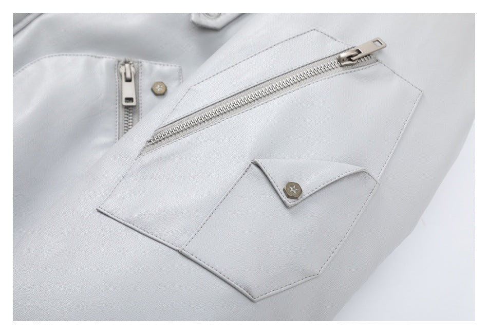 Close-up of a pale gray jacket pocket with a diagonal zipper and a small flap with a star button.