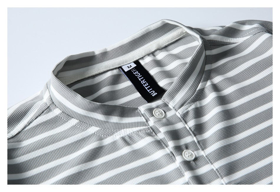 Close-up of a gray-and-white striped shirt's band collar, white buttons, and black neck label.