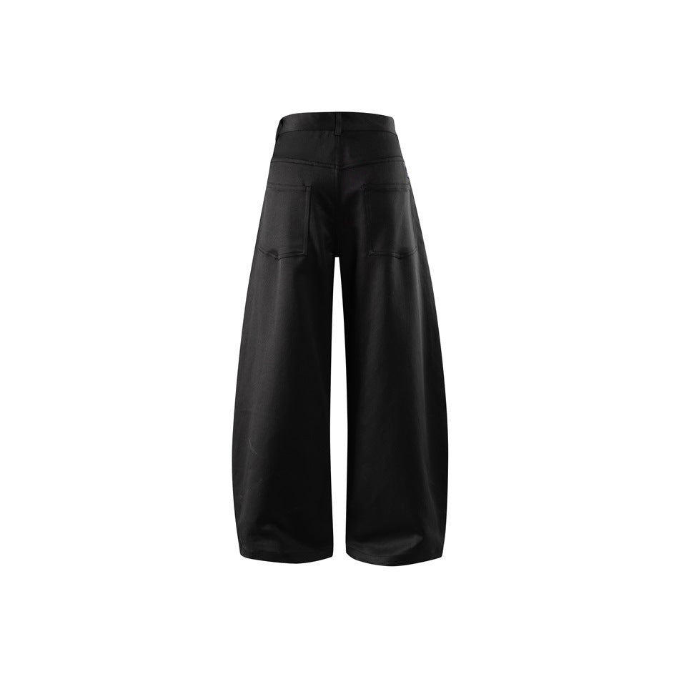 Black wide-leg barrel pants seen from the back with two patch pockets and a yoke, flat view on white